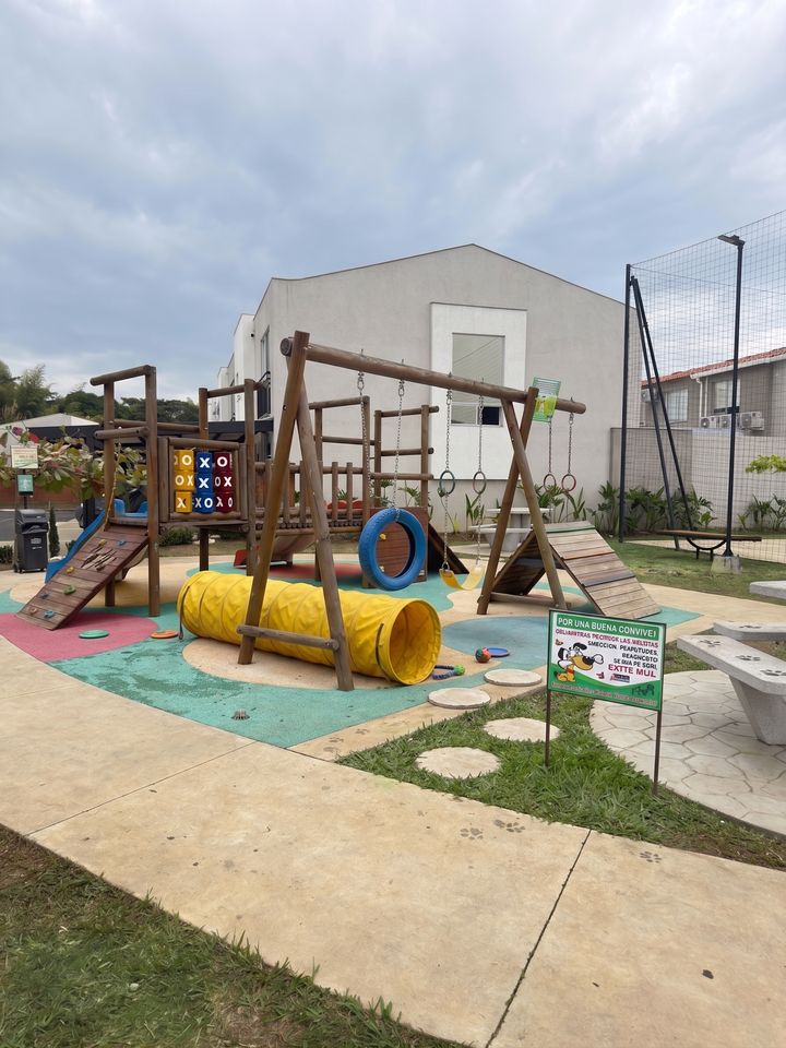 Parque infantil con columpios, rodadero y piso amortiguado de colores